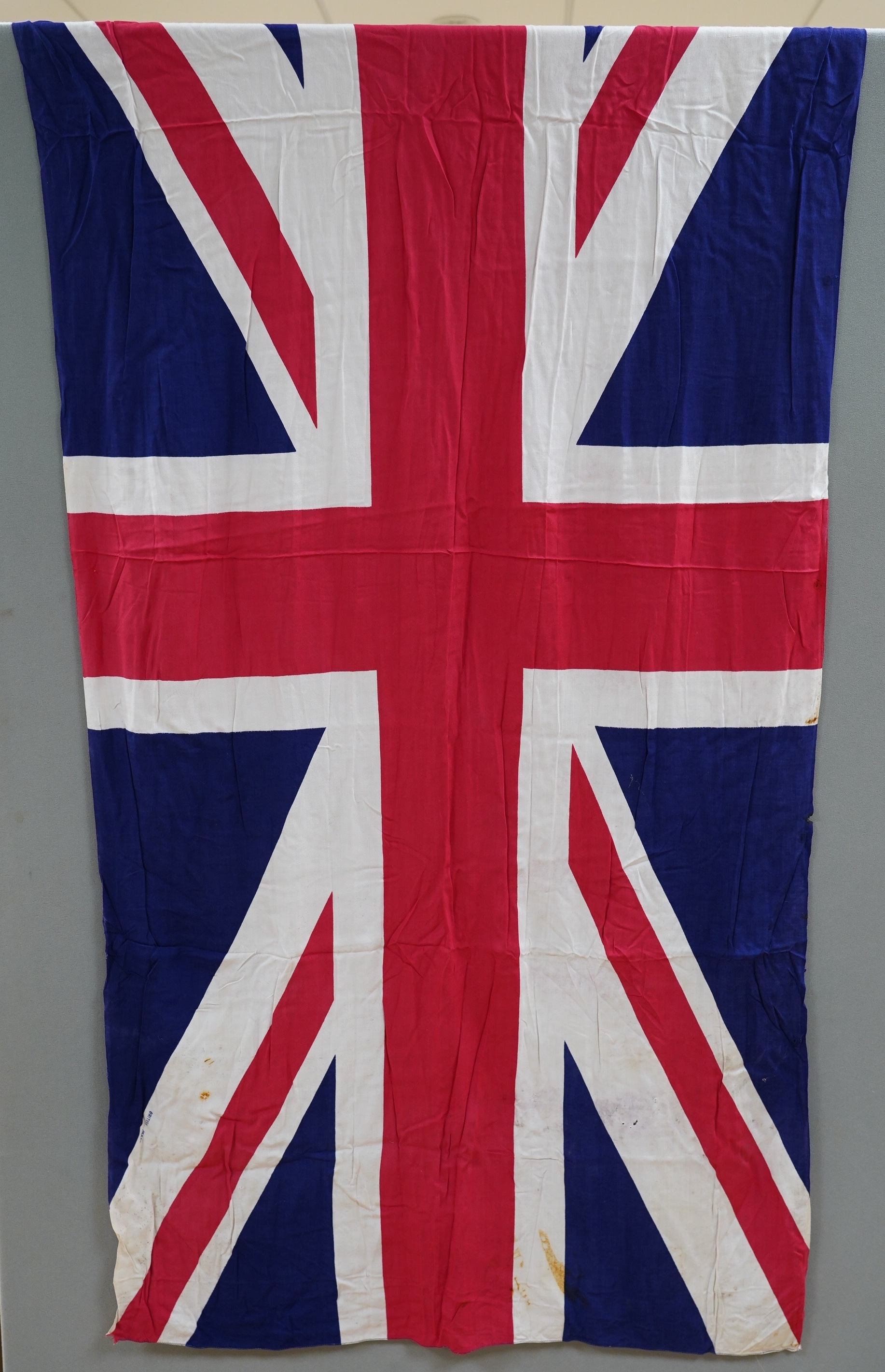 Four early to mid 20th century flags including; two Union Jack flags, a British naval ensign and an American confederate flag, 62 x 86cm. Condition - poor to fair